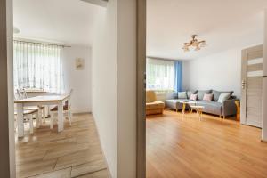 ein Wohnzimmer und ein Esszimmer mit einem Sofa und einem Tisch in der Unterkunft VacationClub – Apartament Waryńskiego 14C in Szklarska Poręba
