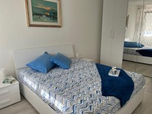 a bedroom with a bed with blue pillows at Sogno di mare in Cavallino-Treporti