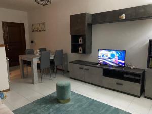 a living room with a tv and a table with chairs at Casa Marsala in Olbia