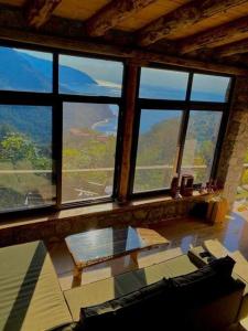 a living room with large windows and a table at 19th Century Neo-Modern KABAK VALLEY STONE HOUSE in Fethiye