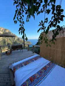 a bench on a wooden deck with a view of the ocean at 19th Century Neo-Modern KABAK VALLEY STONE HOUSE in Fethiye