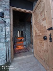 a wooden door leading into a room with a fireplace at 19th Century Neo-Modern KABAK VALLEY STONE HOUSE in Fethiye