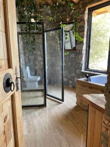 a bathroom with a glass shower with a toilet at 19th Century Neo-Modern KABAK VALLEY STONE HOUSE in Fethiye