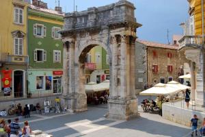 an archway in the middle of a street with buildings at Rooms Aida in Pula