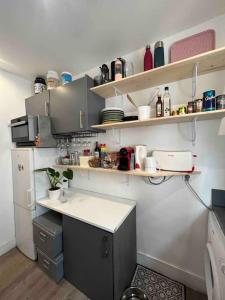 a kitchen with a counter and shelves on the wall at Joli cocon proche de Paris centre in Boulogne-Billancourt