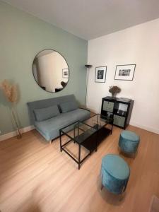 uma sala de estar com um sofá, uma mesa e um espelho em Joli cocon proche de Paris centre em Boulogne-Billancourt