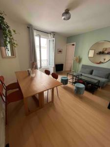 uma sala de estar com uma mesa e um sofá em Joli cocon proche de Paris centre em Boulogne-Billancourt