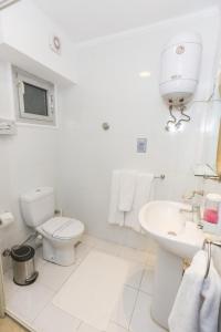 a white bathroom with a toilet and a sink at Jawhara Inn Hotel - فندق الجوهرة سفاجا in Hurghada