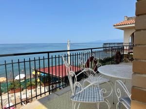 d'un balcon avec une table et des chaises donnant sur l'océan. dans l'établissement Sea Pearl, à Casteldaccia
