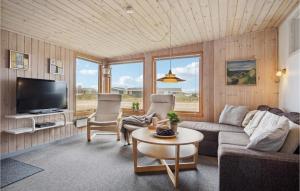 BjerregårdにあるAmazing Home In Hvide Sande With Wifiのリビングルーム(ソファ、椅子、テレビ付)