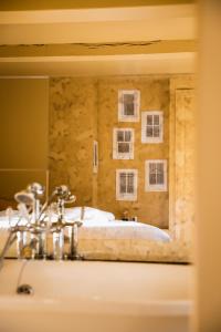 een badkamer met een bed, een wastafel en een spiegel bij pieuX in Montreuil-sur-Mer