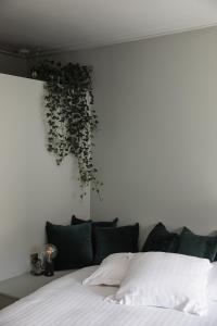 1 dormitorio con 1 cama con una planta en la pared en pieuX, en Montreuil-sur-Mer