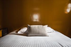 een bed met witte lakens en kussens in een kamer bij pieuX in Montreuil-sur-Mer