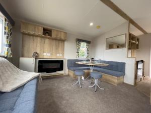 a living room with a couch and a table at Mersea Retreat in West Mersea