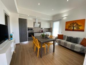 a kitchen and living room with a table and a couch at Casa Mora in San Vero Milis