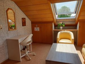 an attic room with a desk and two chairs at Sonnige ruhige Dachzimmer inkl WIFI plus Kaffee mit WG Dusche und neuer Küche in Lörrach