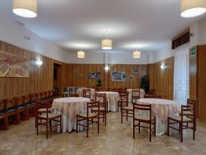 a dining room with tables and chairs and wooden walls at Hotel Stella Alpina in Villalago