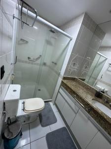 y baño con ducha, aseo y lavamanos. en Flat Hotel Tropical Executive Praia Ponta Negra en Manaos