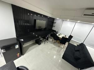 a room with a piano and a table and chairs at Flat Hotel Tropical Executive Praia Ponta Negra in Manaus