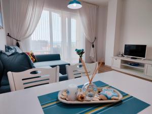een woonkamer met een tafel en een dienblad met eten bij Raya Central Obzor in Obzor
