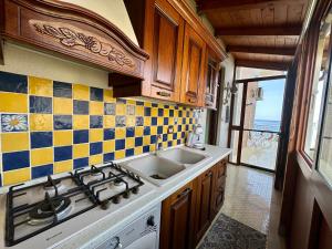 a kitchen with a sink and a stove top oven at Sea Pearl in Casteldaccia