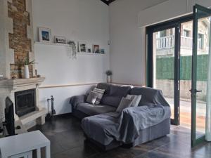 a living room with a couch and a fireplace at Villa Lucerna, villa con piscina en Pantín in Pantín