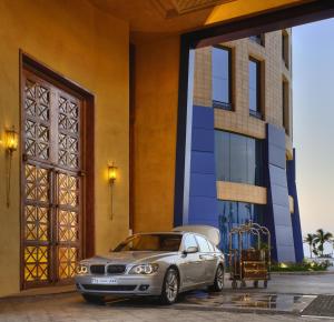 ein silbernes Auto, das vor einem Gebäude parkt in der Unterkunft Rosewood Jeddah in Dschidda