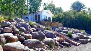 una pequeña casa en medio de un montón de rocas en Loft-Sleeps5-Parking-Spa-LakeViews-PetFriendly, en Finnerödja