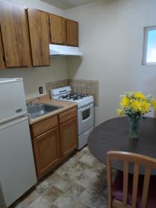 a kitchen with a stove and a sink and a table at Budget Inn Morgan Hill in Morgan Hill