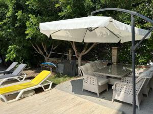 a patio with a table and chairs and an umbrella at Villa Marla in Side