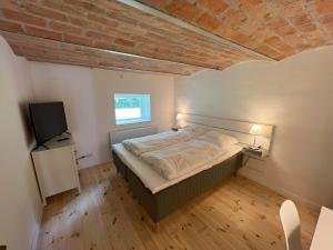 a bedroom with a bed and a television in it at Solbjerg Skov B&B in Solbjerg