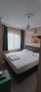 sypialnia z dużym białym łóżkiem przed oknem w obiekcie Hotel Crowded House w mieście Eceabat