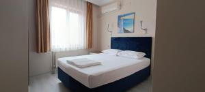 ein Schlafzimmer mit einem Bett, auf dem zwei Handtücher liegen in der Unterkunft Hotel Crowded House in Eceabat