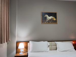 1 dormitorio con 1 cama con una foto de un caballo en Bobi Hotel, en Shkodër