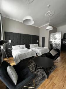 a bedroom with two beds and a couch and a table at Amani Apartments - Glasgow City Centre in Glasgow