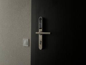 Una puerta negra con control remoto. en Luxuria Modern Apartments - Self Check-in, en Šiauliai