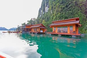eine Reihe von Häusern auf dem Wasser neben einem Berg in der Unterkunft Panvaree Resort in Ban Chieo Ko