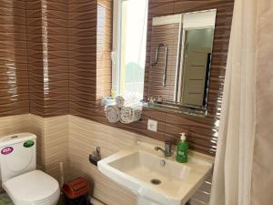 a bathroom with a sink and a toilet and a mirror at Large modern apartment mix style in Dushanbe