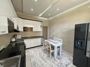 a kitchen with a table and chairs in a room at Large modern apartment mix style in Dushanbe