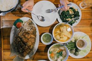 Panvaree Resort في Ban Chieo Ko: طاولة مع أطباق من الطعام وأوعية من الطعام