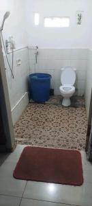 a bathroom with a toilet and a blue tub at Akria Bed and breakfast in Bayan