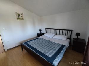 um quarto com uma cama com um cobertor azul em Apartment Zelena oaza Sisan 75 m2 - 2 bedrooms em Sisan