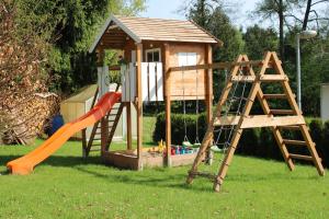 a playground with a slide and a play house at Ferienhaus am Mühlteich in Lindenberg