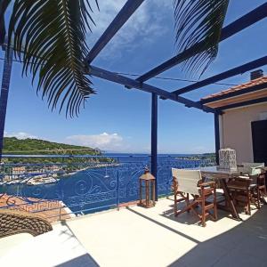 a patio with a table and chairs and a view of the ocean at Odysseus Suite in Kiónion