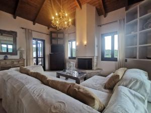 a living room with a couch and a chandelier at Odysseus Suite in Kiónion