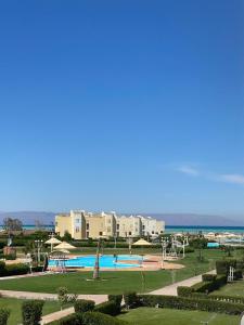 a resort with a swimming pool and buildings and the ocean at Chalet - Calipsio neighbourhood in Ras Sedr