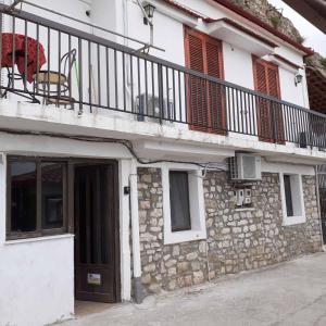 a stone building with a balcony and a door at Stone Clock's House in Nafpaktos