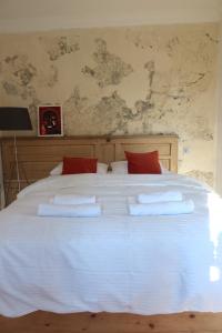 uma grande cama branca com almofadas vermelhas em Wonderer House in Batumi's Old City em Batumi