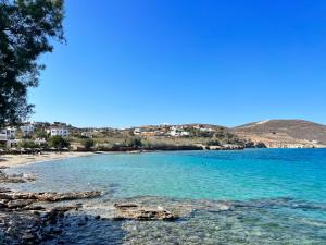 a view of a beach with blue water and houses at Casa Fabrica in Ano Syros