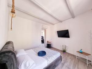 a white bedroom with a bed and a couch at Suite Cornelia in Santa Teresa Gallura